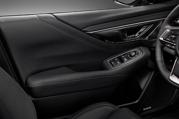 Subaru vadītāja durvju iekšpuse ar roku balstu un pogām elektriskajiem logiem un spoguļu regulēšanai.